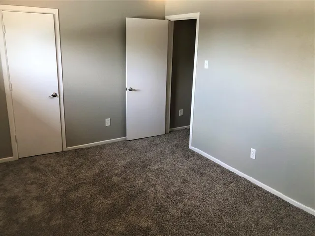 an empty room with closet and bathroom