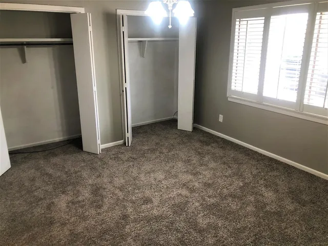 an empty room with windows and closet