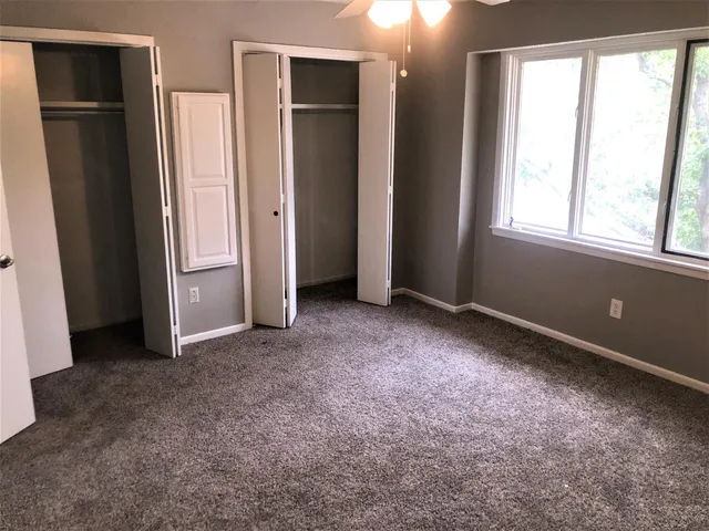 an empty room with windows and closet