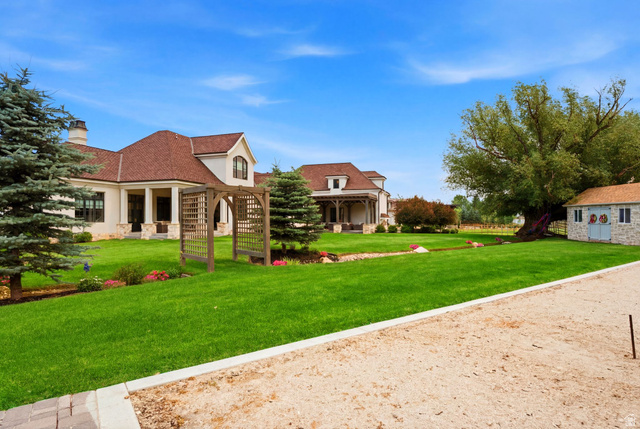 71 Farm Road Midway, UT 84049 - Photo 77 of 92 Expansive green lawn with mature evergreen trees and a decorative wooden archway