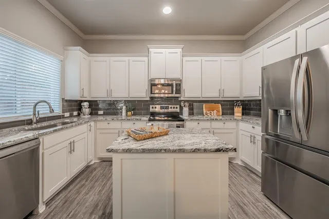 a kitchen with stainless steel appliances granite countertop a refrigerator sink and stove