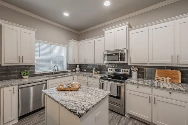 a kitchen with stainless steel appliances granite countertop a sink stove and refrigerator