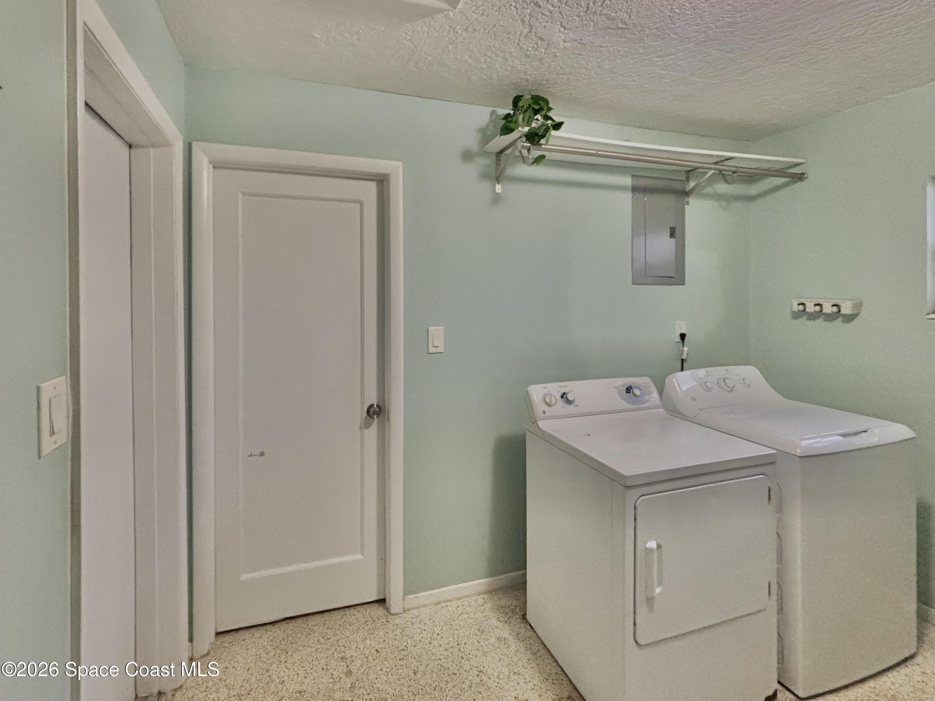 987 Kings Post Road Rockledge, FL 32955 - Photo 30 of 30 a utility room with cabinets washer and dryer