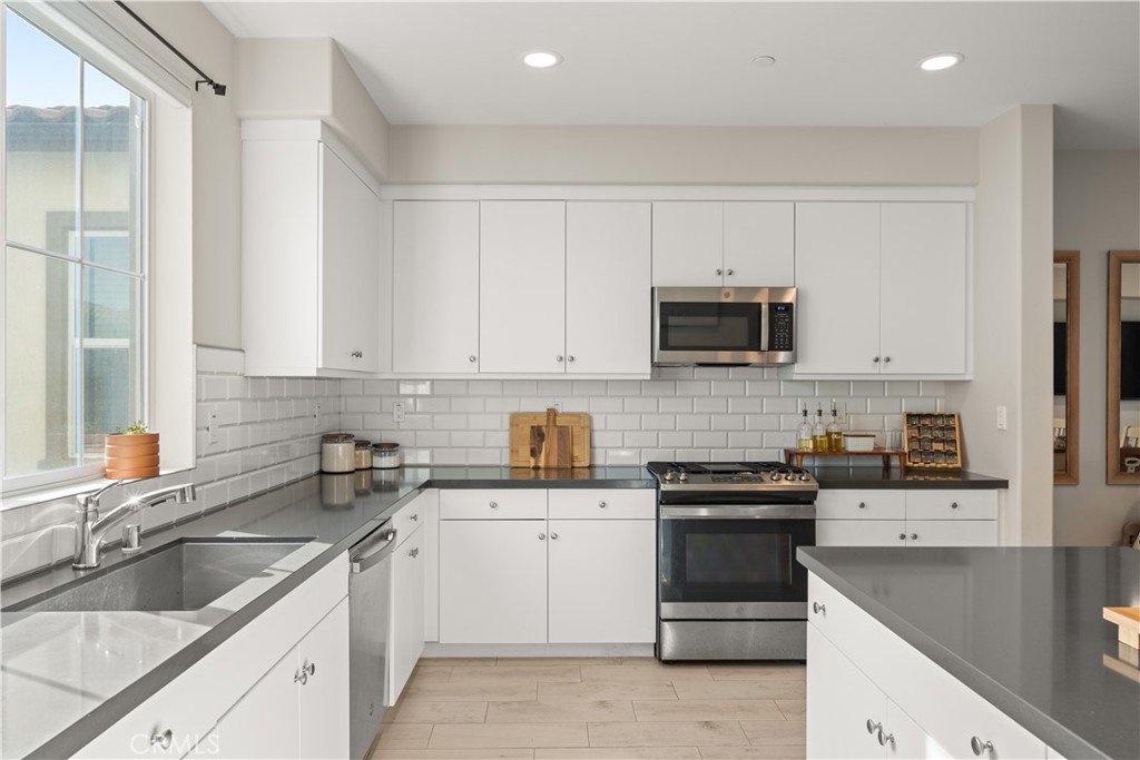 31305 Via Nubes Temecula, CA 92592 - Photo 11 of 27 a kitchen with granite countertop white cabinets and stainless steel appliances