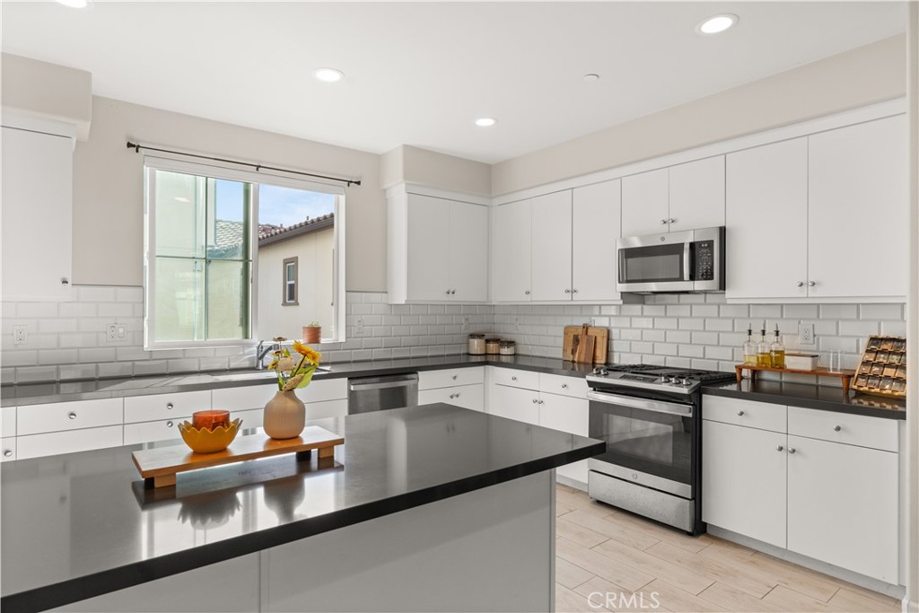 31305 Via Nubes Temecula, CA 92592 - Photo 7 of 27 a kitchen with granite countertop a sink a stove and cabinets