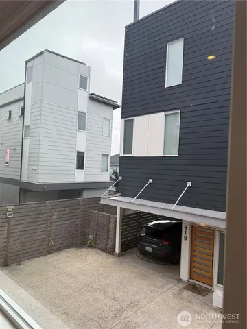 a view of a house with a barbeque and wooden stairs
