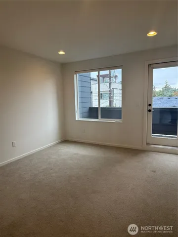 an empty room with windows and fireplace