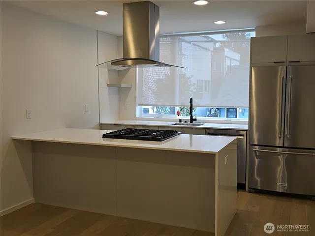 a kitchen with stainless steel appliances granite countertop a refrigerator a sink and a stove