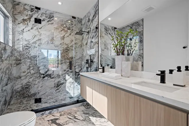 a bathroom with a granite countertop sink a toilet and shower