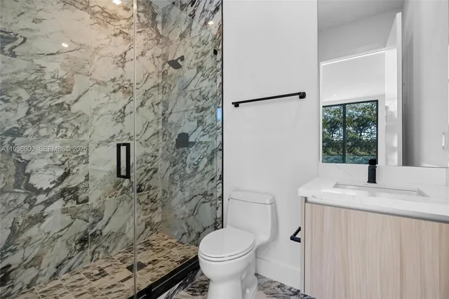 a bathroom with a granite countertop toilet and a sink