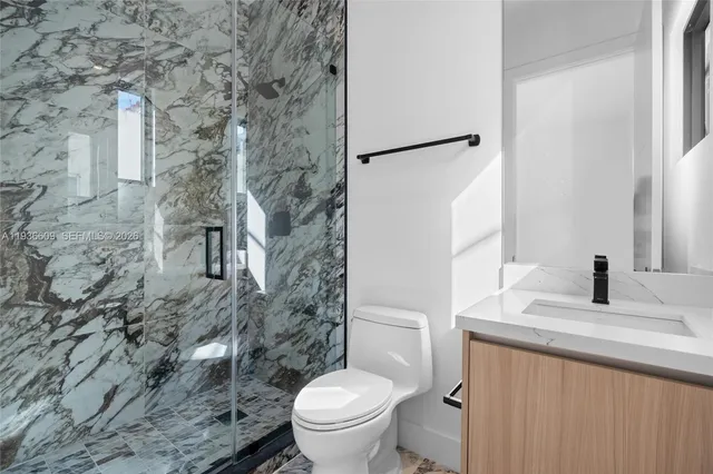 a white toilet sitting next to a bathroom sink