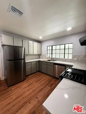 a kitchen with stainless steel appliances a refrigerator sink and cabinets