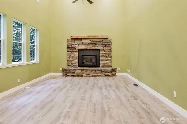 a view of empty room with fireplace and wooden floor