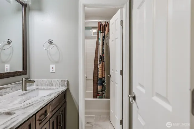 a bathroom with a granite countertop sink and a mirror