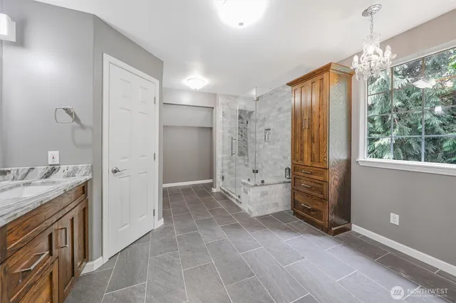 a bathroom with a granite countertop sink a mirror and a shower