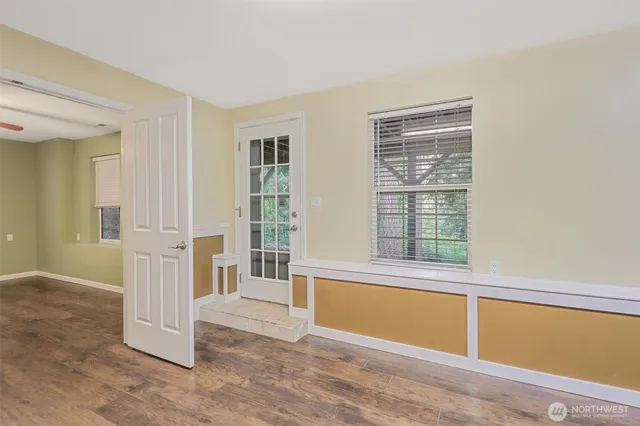 an empty room with wooden floor and windows