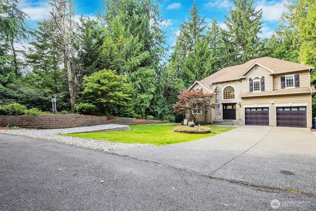 a front view of a house with a yard and trees