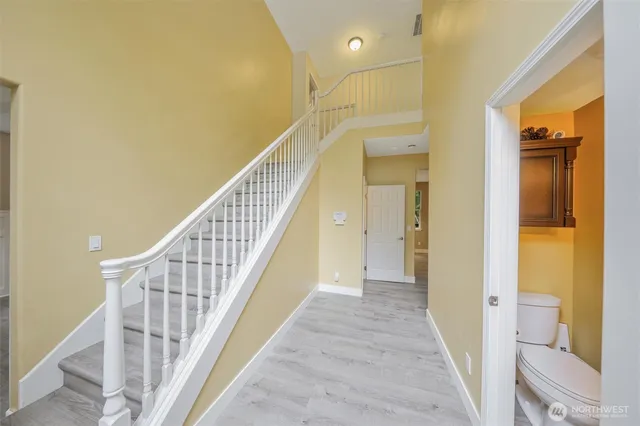 a view of a hallway with wooden floor and staircase