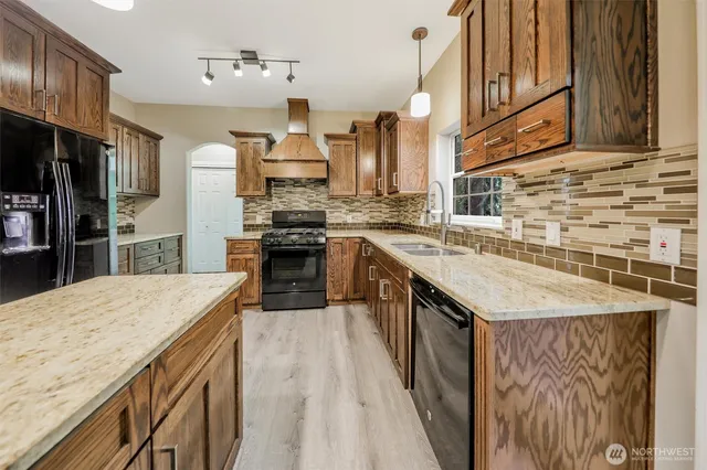 a kitchen with stainless steel appliances granite countertop a sink stove and refrigerator