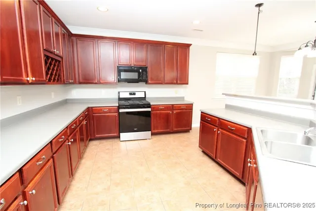 a kitchen with stainless steel appliances granite countertop wooden cabinets a stove top oven a sink and dishwasher