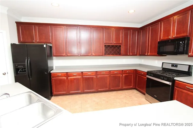 a kitchen with granite countertop wooden cabinets a refrigerator and a sink