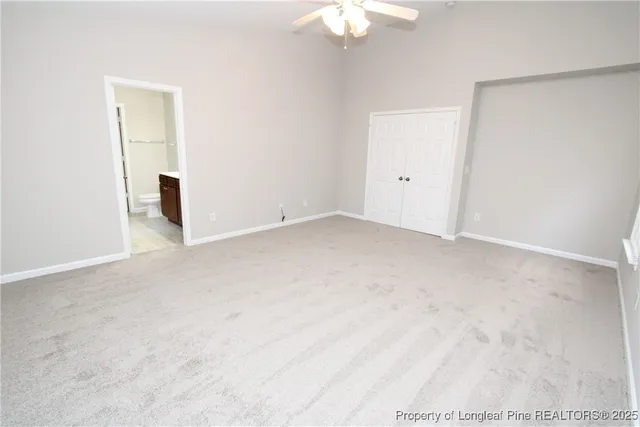 an empty room with a chandelier fan