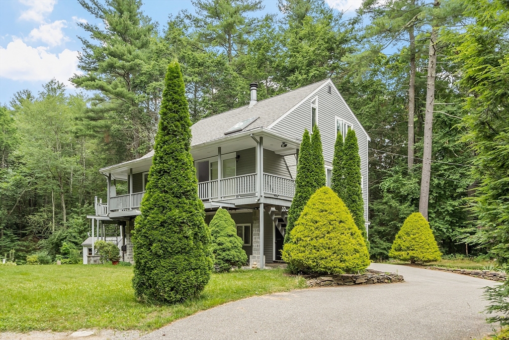 a view of house with outdoor space garden and tall tree