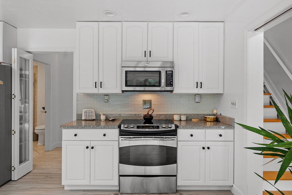 18 Crane Crossing Road Plaistow, NH 03865 - Photo 14 of 36 a kitchen with granite countertop white cabinets and black appliances