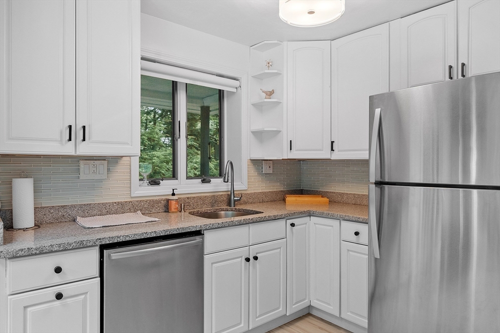 18 Crane Crossing Road Plaistow, NH 03865 - Photo 16 of 36 a kitchen with stainless steel appliances granite countertop a refrigerator sink and cabinets