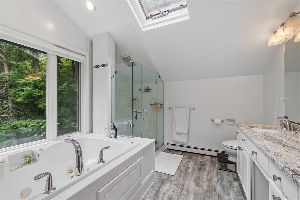 18 Crane Crossing Road Plaistow, NH 03865 - Photo 29 of 36 a bathroom with a tub a sink and a large mirror