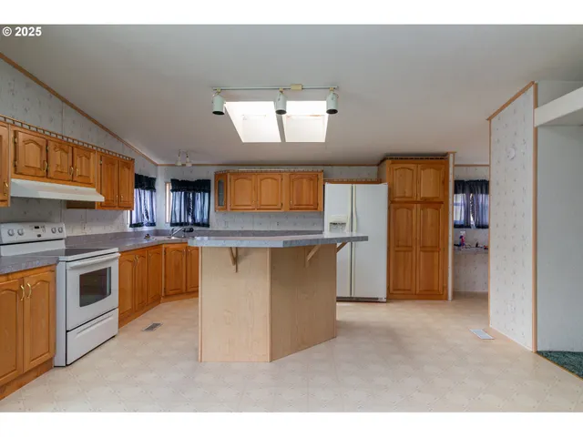 a kitchen with stainless steel appliances a stove a sink and a refrigerator