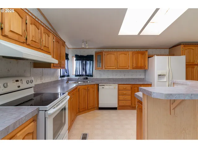 a kitchen with granite countertop a sink a stove and cabinets