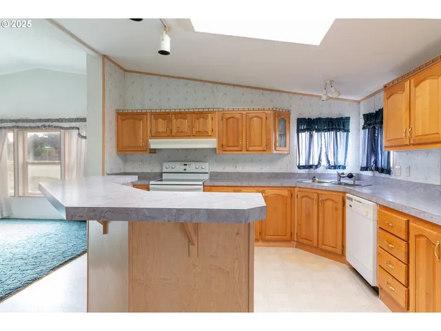 a kitchen with stainless steel appliances granite countertop a sink a stove counter space and cabinets