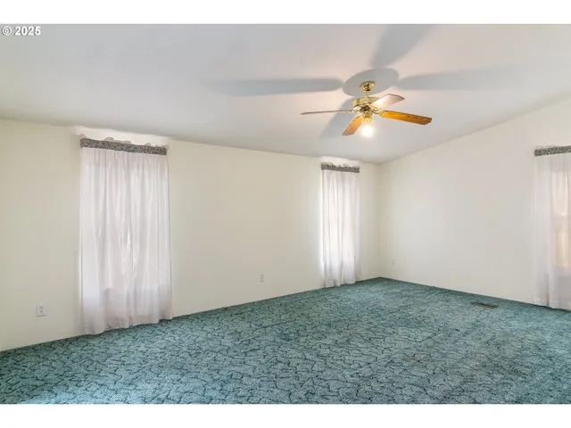 a view of a room with a ceiling fan and a window