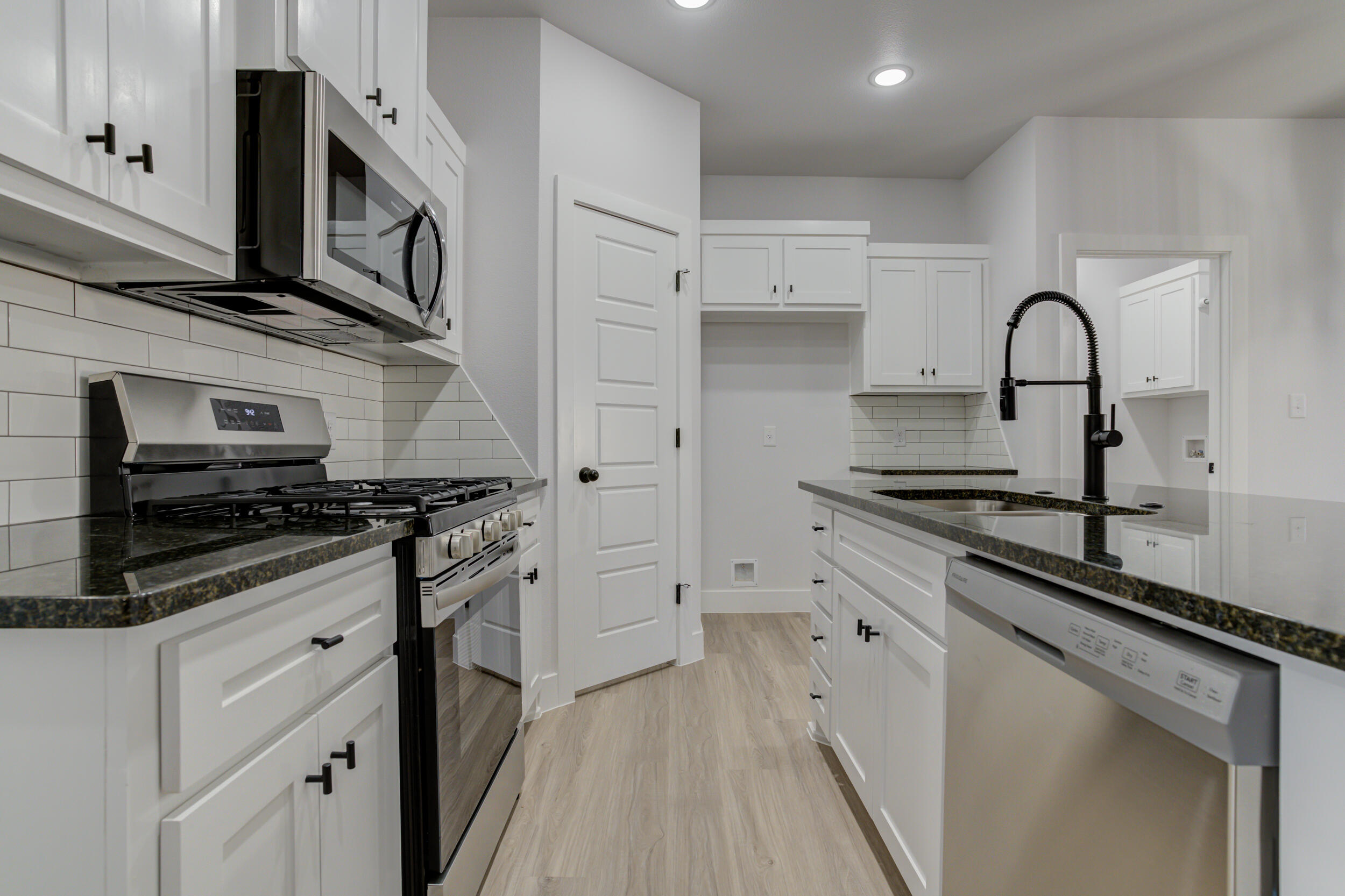 5808 Viola Avenue Lubbock, TX 79407 - Photo 18 of 60 a kitchen with stainless steel appliances granite countertop a stove a sink and a microwave