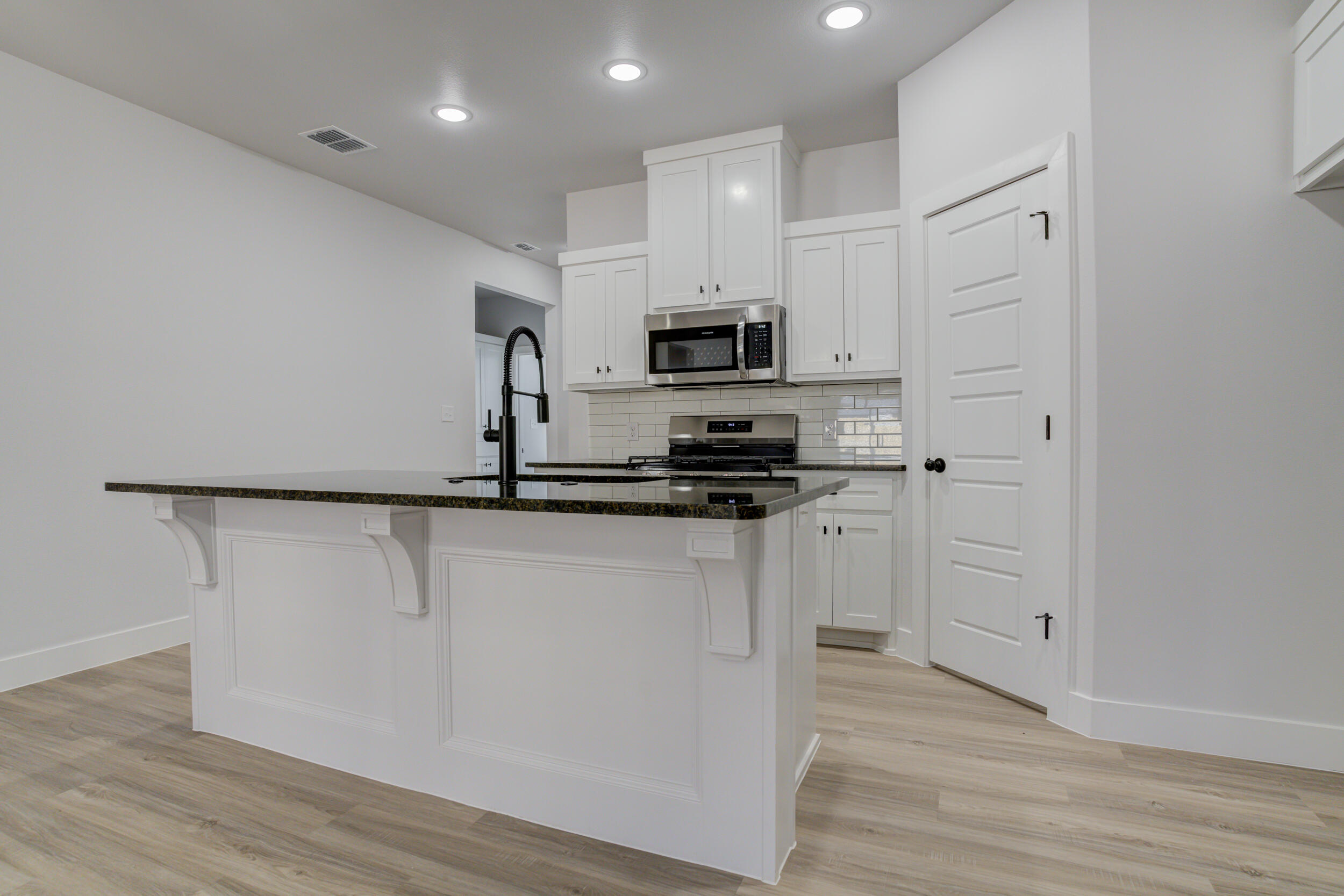 5808 Viola Avenue Lubbock, TX 79407 - Photo 23 of 60 a kitchen with white cabinets and stainless steel appliances