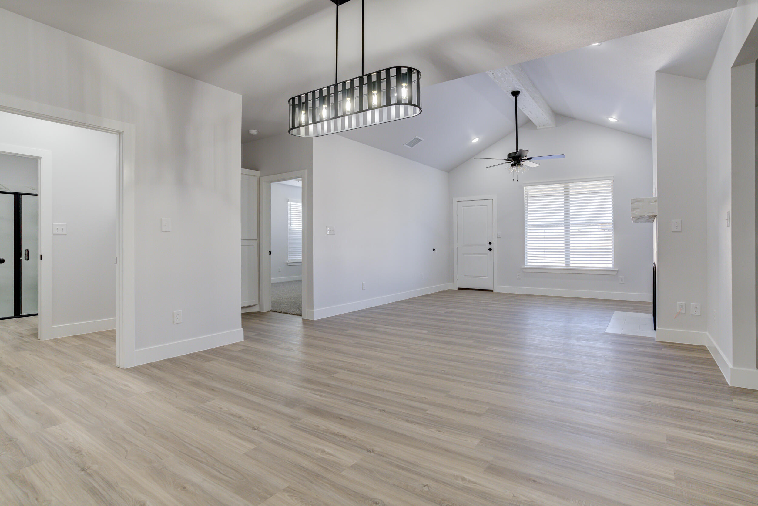5808 Viola Avenue Lubbock, TX 79407 - Photo 26 of 60 an empty room with wooden floor chandelier and windows