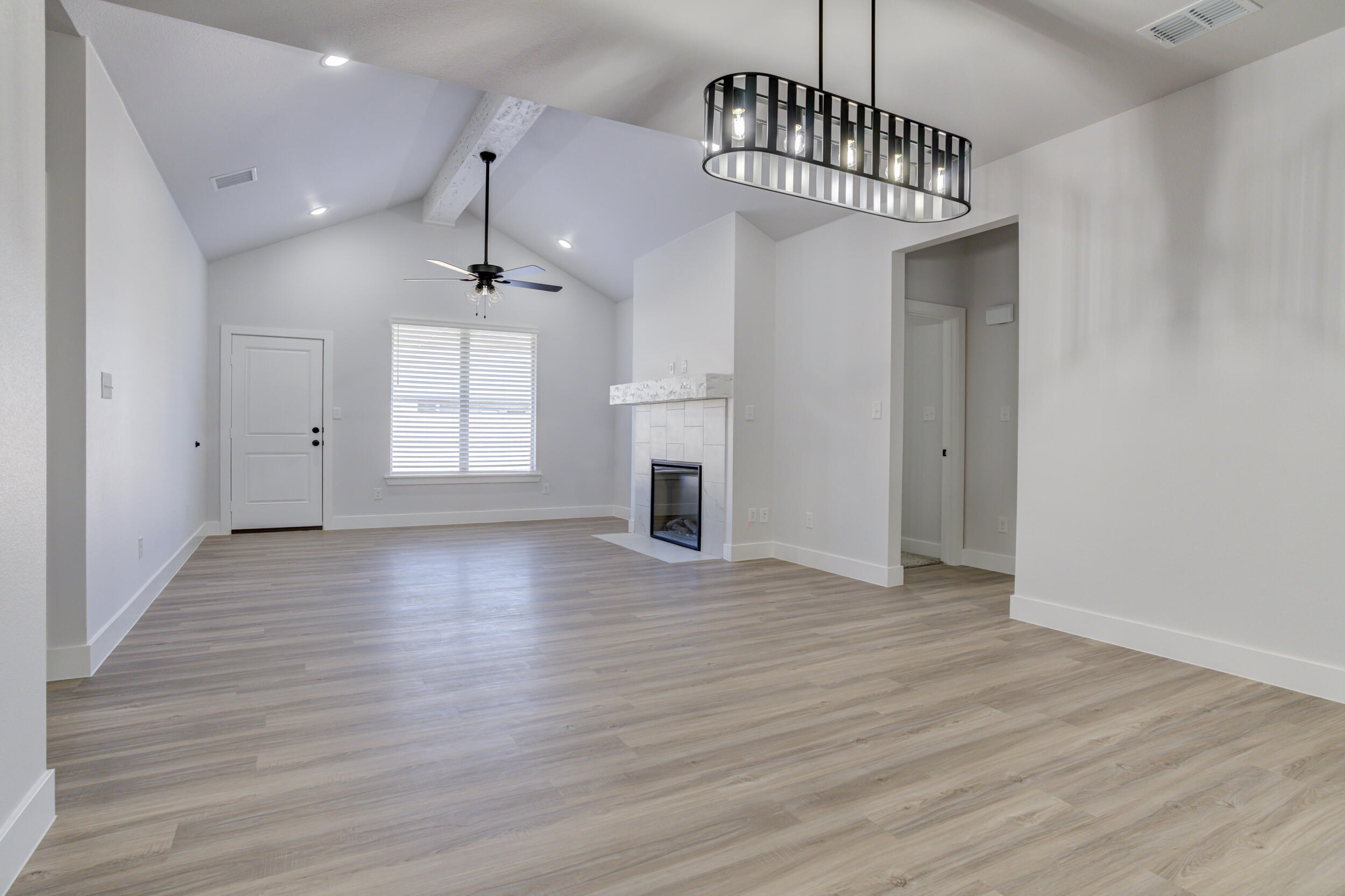 5808 Viola Avenue Lubbock, TX 79407 - Photo 27 of 60 a view of an empty room with wooden floor and a window