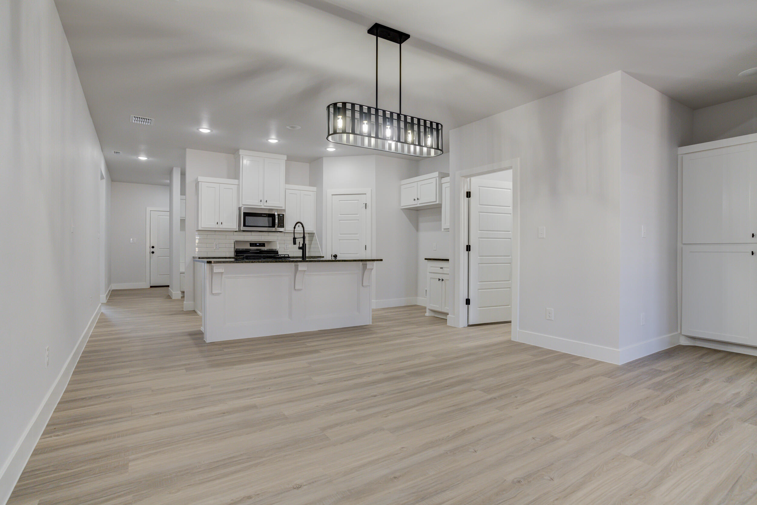 5808 Viola Avenue Lubbock, TX 79407 - Photo 29 of 60 a view of a kitchen with a sink and dishwasher a refrigerator with wooden floor