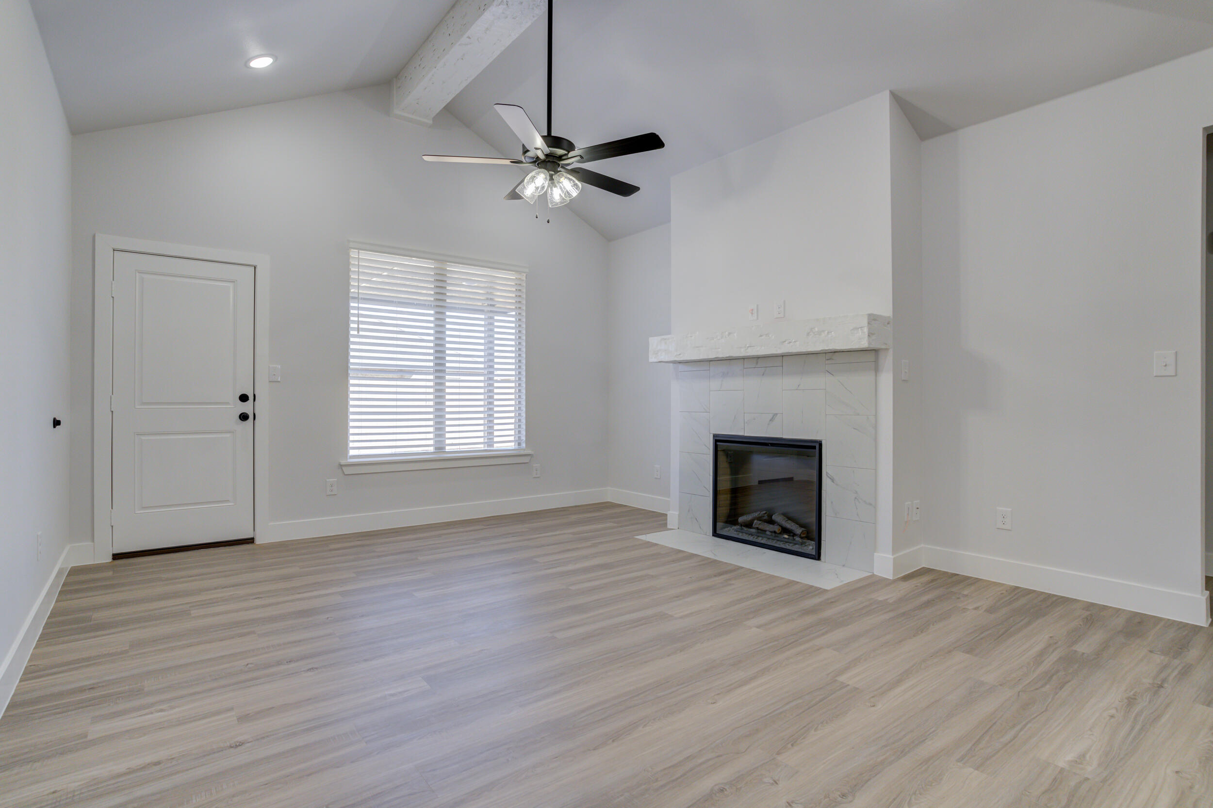 5808 Viola Avenue Lubbock, TX 79407 - Photo 30 of 60 an empty room with wooden floor fireplace and windows