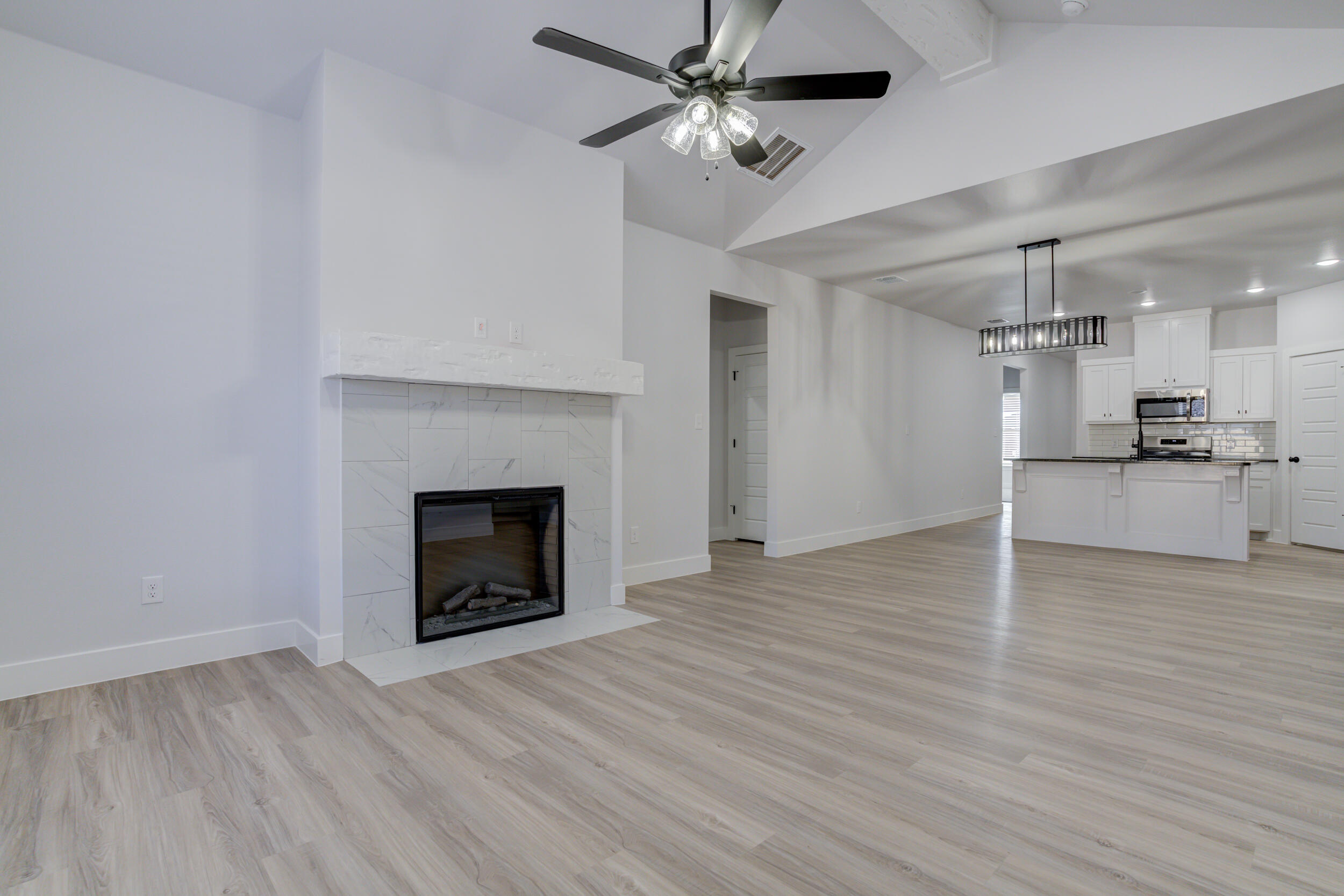 5808 Viola Avenue Lubbock, TX 79407 - Photo 32 of 60 a view of a livingroom with a fireplace and a ceiling fan