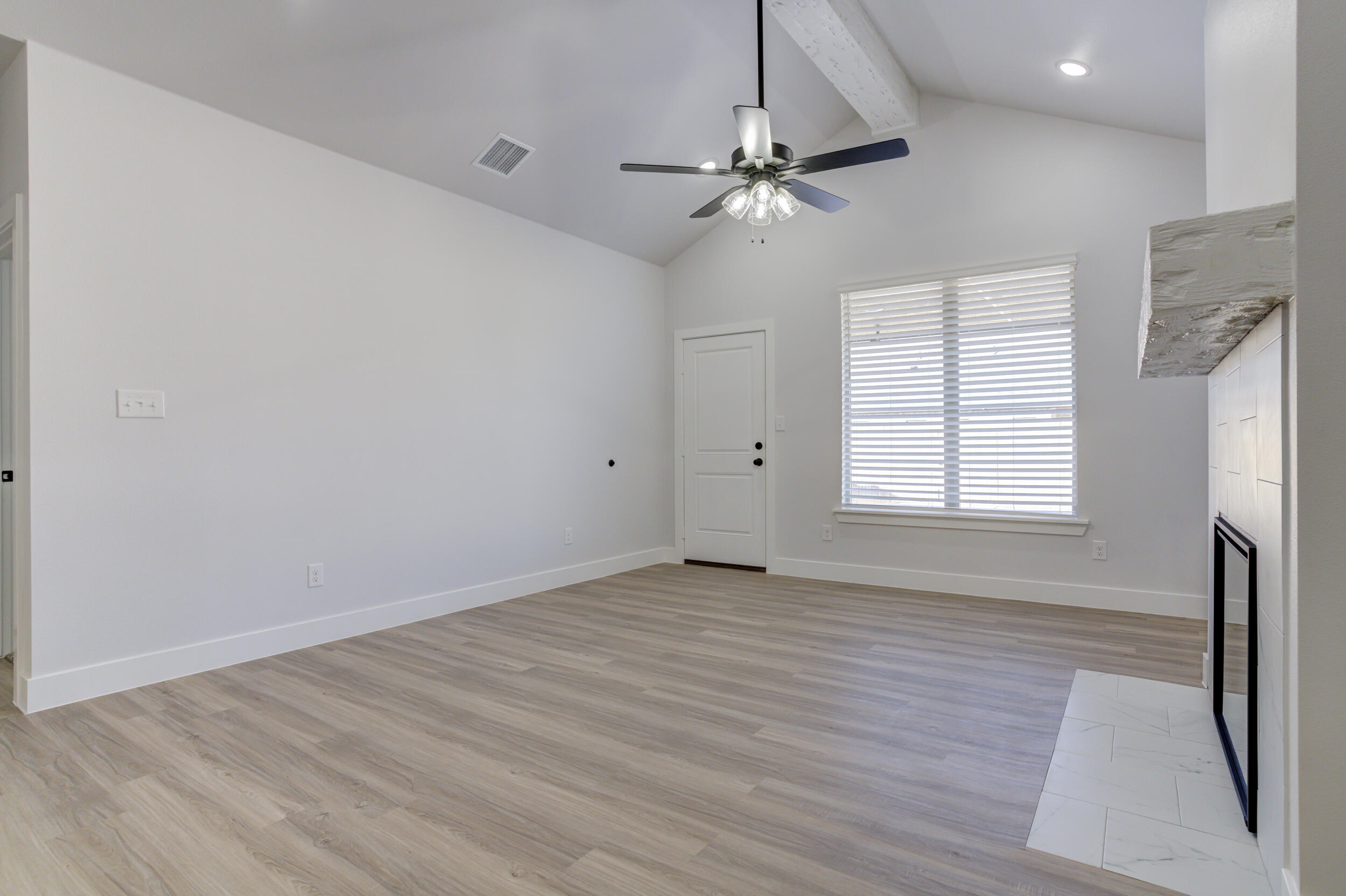 5808 Viola Avenue Lubbock, TX 79407 - Photo 35 of 60 a view of an empty room with wooden floor and a window