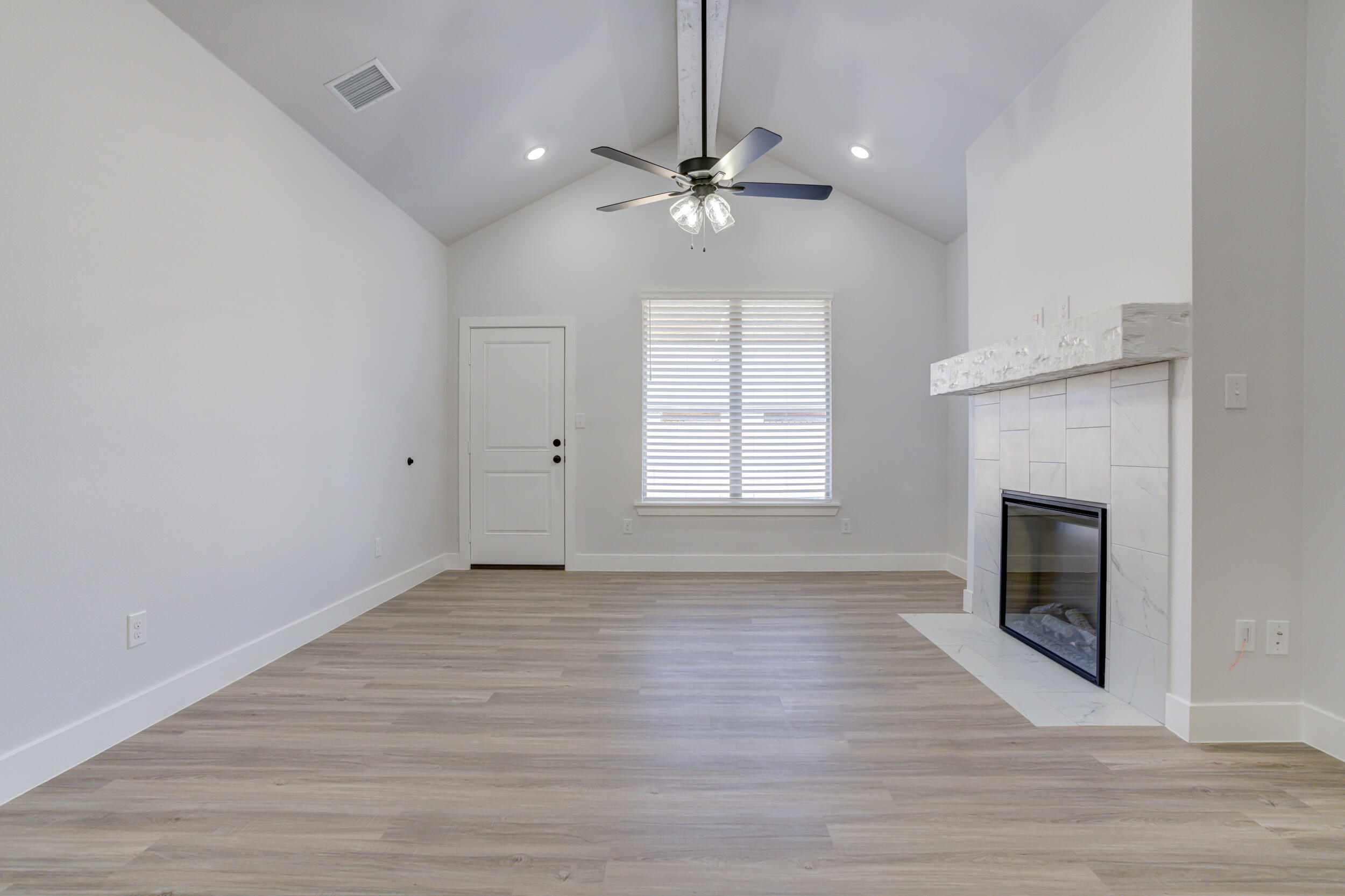 5808 Viola Avenue Lubbock, TX 79407 - Photo 36 of 60 an empty room with wooden floor fireplace and windows