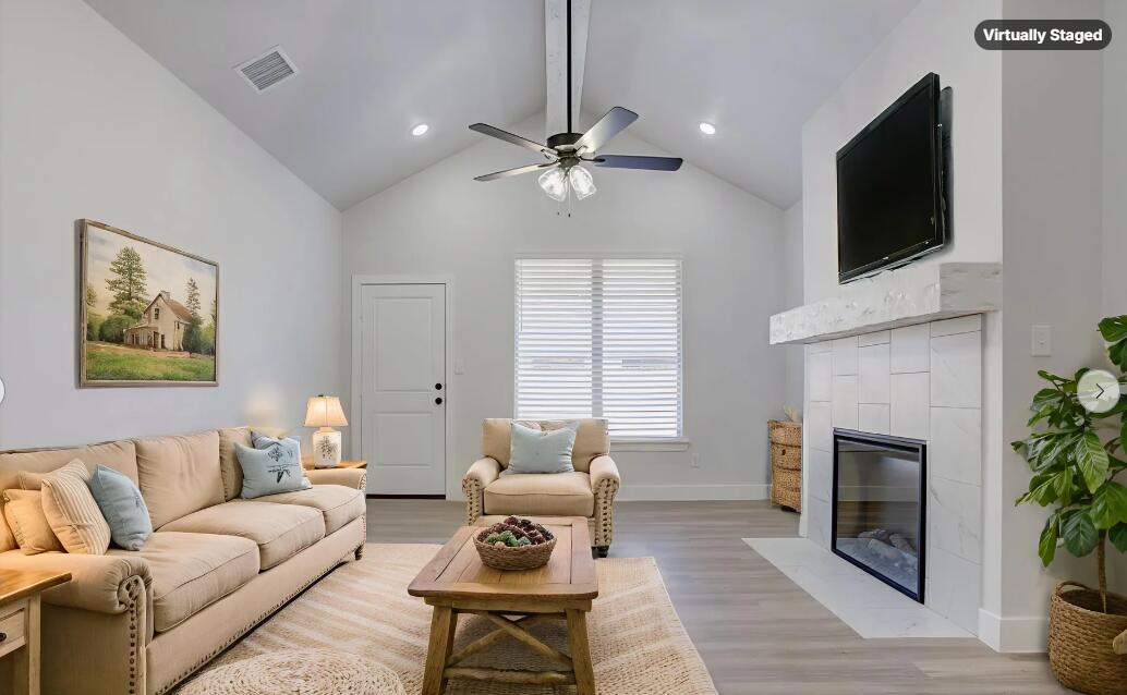 5808 Viola Avenue Lubbock, TX 79407 - Photo 4 of 60 a living room with furniture a fireplace and a flat screen tv