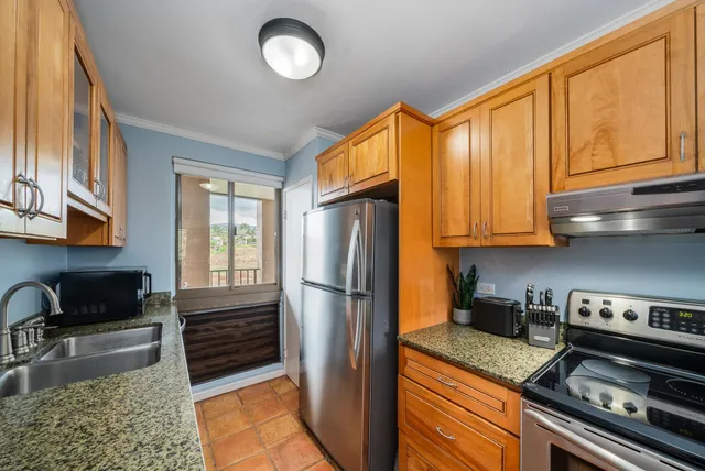 a kitchen with granite countertop stainless steel appliances and wooden cabinets