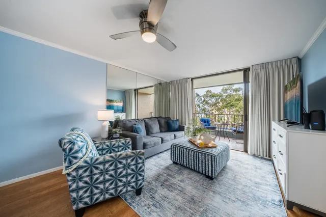 a living room with furniture a flat screen tv and a window