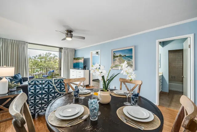 a view of a dining room with furniture a rug and wooden floor
