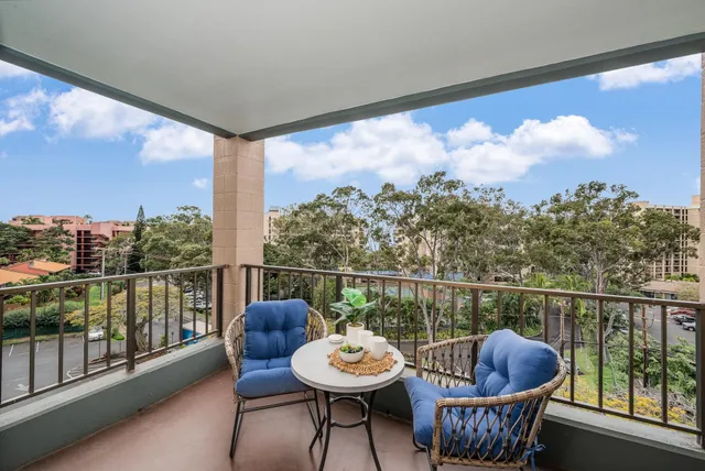a view of a balcony with chairs and a potted plant