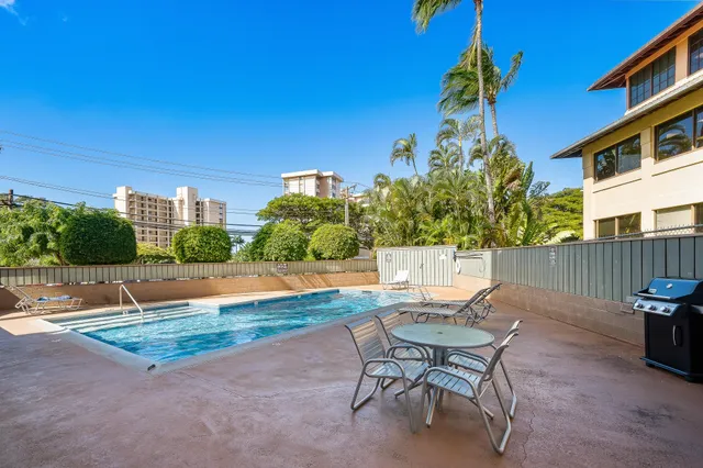 a view of a swimming pool with a patio and a yard