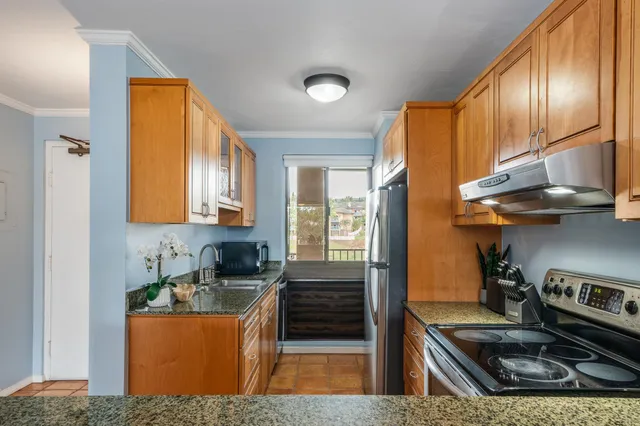 a kitchen with stainless steel appliances granite countertop a stove a sink and a refrigerator